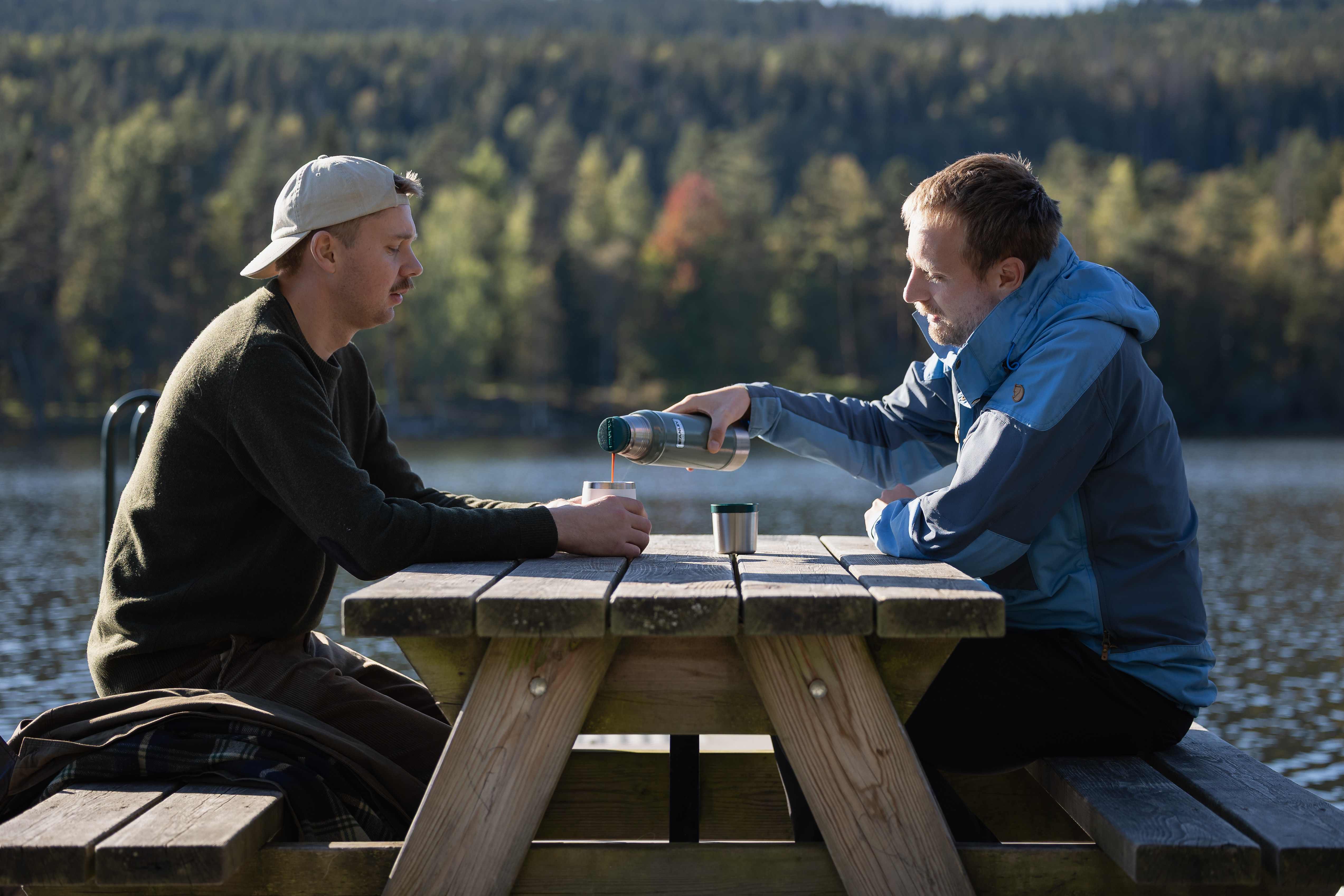 Menn som prater sammen på en benk i naturen